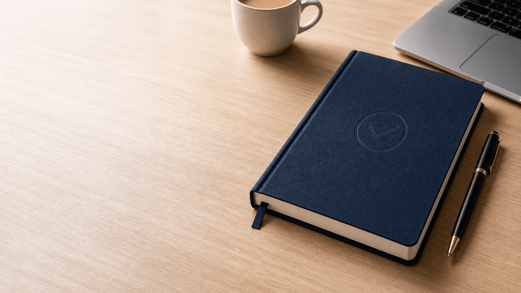Regulatory-exam study notebook, pen and laptop on a professional desk